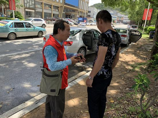 易雄和小谭堂哥交流小谭回家后的注意事项。新京报记者周小琪&nbsp;摄