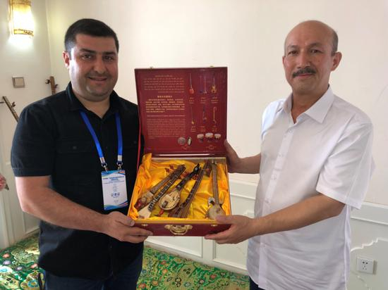 　　图7土耳其《光明报》记者吐奇·阿科奇（左）采访曾被土方谣传“已死”的维吾尔族音乐家艾衣提（右）。