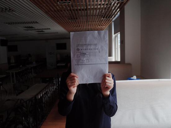 张女士手持在清沁医疗美容门诊部的就诊记录。&nbsp; 新京报实习生 陈婉婷 摄