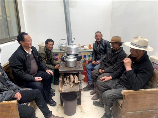 古桑旦增（左一）在杰罗布村向牧民们了解生产生活与守边情况。人民网 宋晨 摄