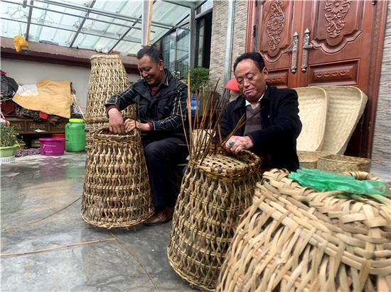 古桑旦增走访入户，与村民一起编织箩筐。人民网 宋晨 摄
