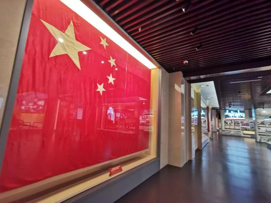 　△毛泽东主席在开国大典上按动电钮升起的国旗。