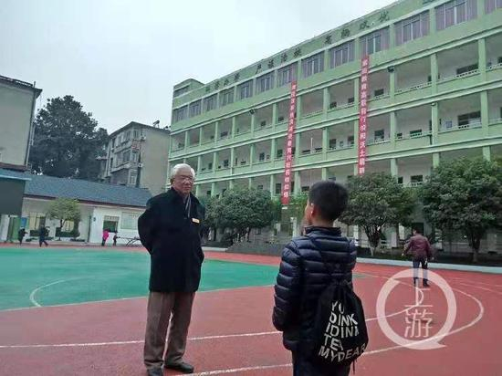 2018年12月5日，湖北赤壁正扬小学内75岁的校长吴震球在和学生对话。