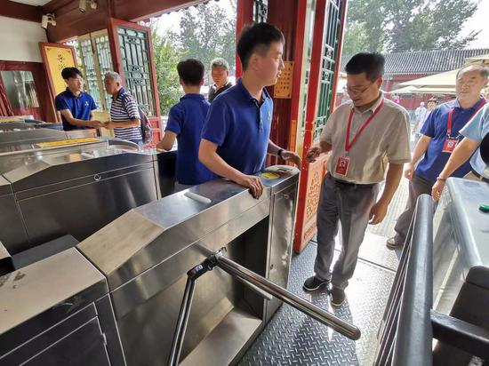 恭王府博物馆馆长冯乃恩演示网上购票后刷身份证进馆。摄影/新京报记者 浦峰