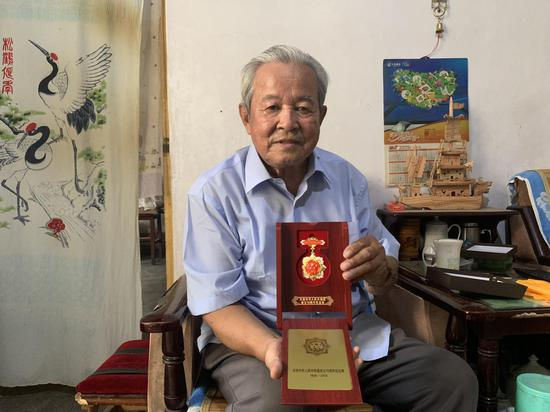9月26日，韩泽民在家中拿出“庆祝中国成立70周年纪念奖章”。新京报记者 左燕燕 摄