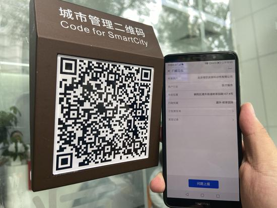 市民扫商户门口的二维码即可上报信息。新京报记者 王贵彬 摄