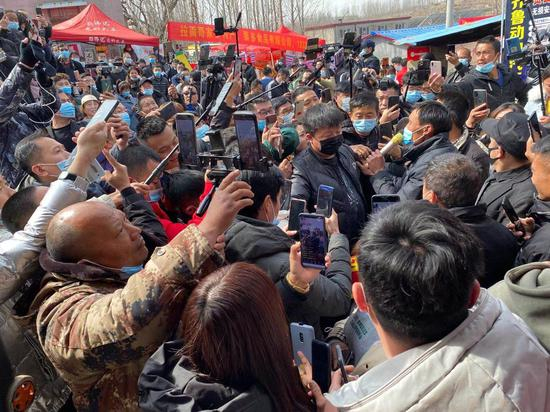 程运付（拿话筒者）刚走出家门，几百台手机高高低低就包围住他。新京报记者肖薇薇摄
