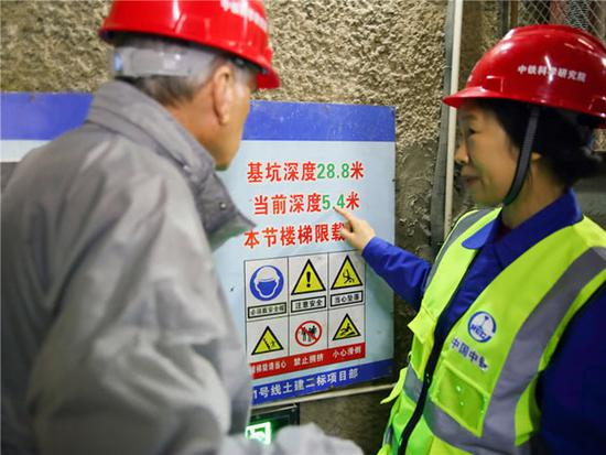 严金秀向年近80岁的国际隧道协会前主席艾纳。布洛克先生提醒竖井当前深度&nbsp; 图自人民网