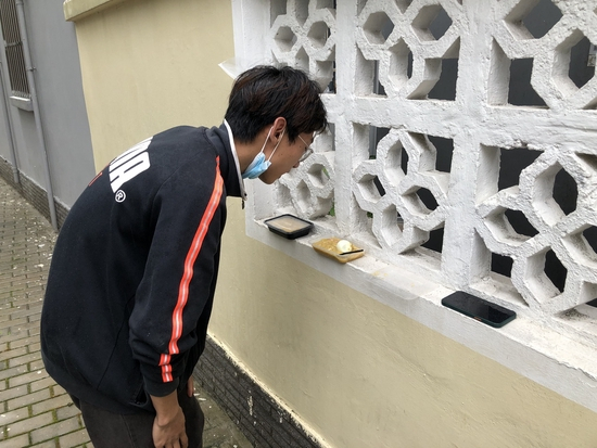 　东昌路地铁站附近，孙武在女朋友所在的小区旁边吃饭，女朋友从镂空墙把饭递出来。
