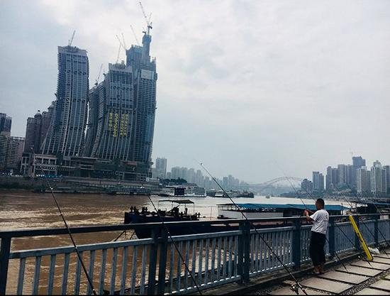 长年在长江边钓鱼的卢先生见证了来福士广场从无到有的建设全过程（刘向南摄）