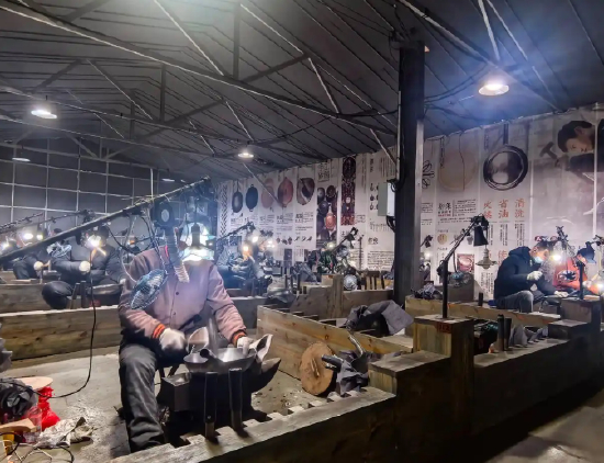 正在锻打章丘铁锅的匠人。