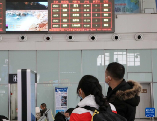 1月2日，旅客在福州火车站候车厅观看大屏幕播放的主题歌曲《领航》MV。新华社发（李一明 摄）