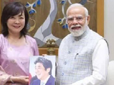安倍晋三遗孀手捧安倍画像与莫迪合影