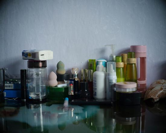 护肤品排列在桌前。高明是“八四”毒气事件中年龄最小的受害者之一，中毒时不满8岁。