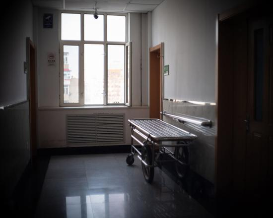 铁架床边的瓷砖地是李臣平时的活动区域，腿脚不便的他只能在这里数着地上的格子活动筋骨。