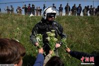 希腊警察阻止难民入境 意外收到鲜花