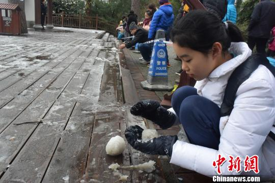 一名小姑娘在把玩积雪。 蒋雪林 摄