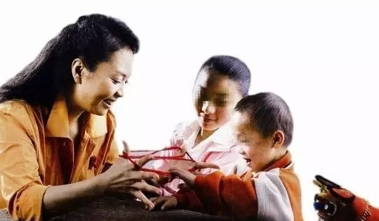 2006年，彭丽媛在安徽阜阳市与艾滋病患儿做游戏。