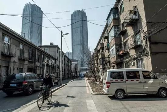 中捷友谊厂的职工宿舍楼依然存在，而当年的工厂已被远处的高楼大厦所取代