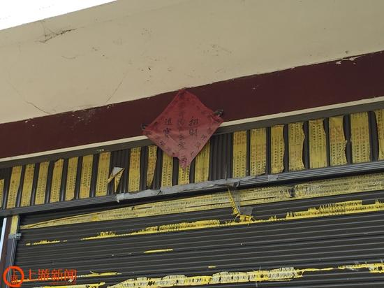 “艾三妹”艾汪全家新修的二层楼房，一楼外贴着招财符。