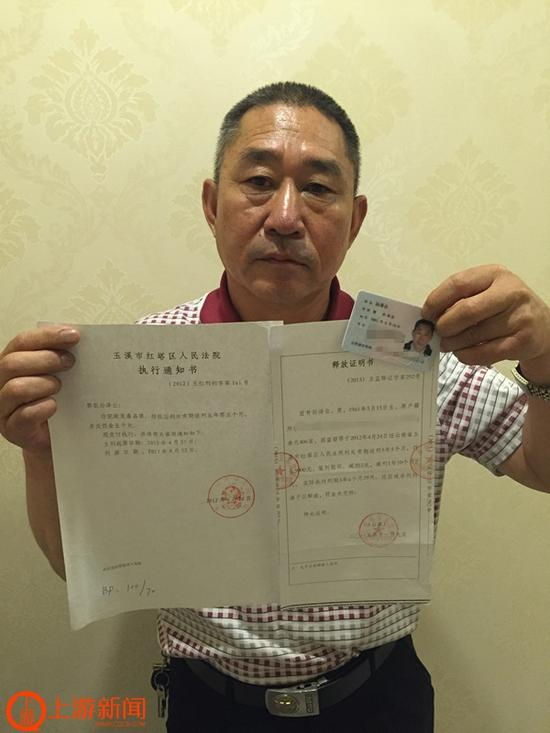 孙泽云拿着《执行通知书》和《释放证明书》。