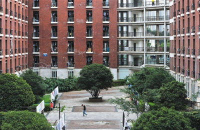 6月18日，昆明理工大学津桥学院，一名男生从事发的男生宿舍楼前走过。新京报记者 薛珺 摄