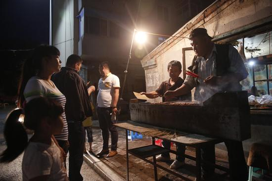 李刚在朋友的烧烤摊烤串