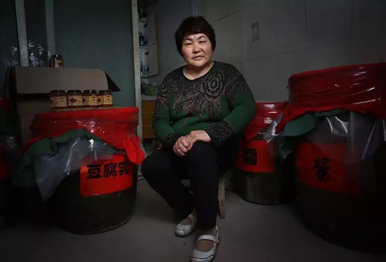 10月16日，河南项城，李桂英坐在家中制作豆腐乳和酱的屋子内。新京报记者尹亚飞 摄
