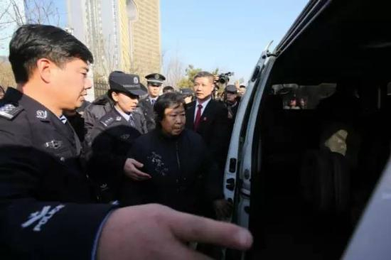 　　2016年12月2日，沈阳。庭审结束后，聂树斌母亲张焕枝由法院工作人员护送上车离开法院。新京报记者王飞 摄