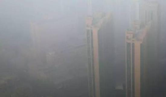 12月19日，石家庄市再次遭遇严重雾霾天气，市区内的建筑物笼罩在雾霾中。图/视觉中国