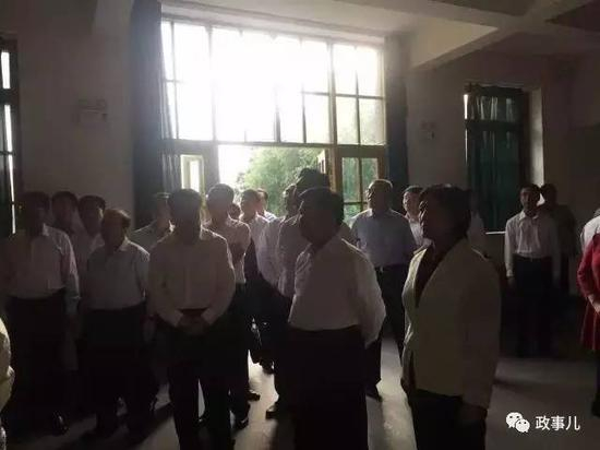 参观时，布小林肃穆站立，静默观看。