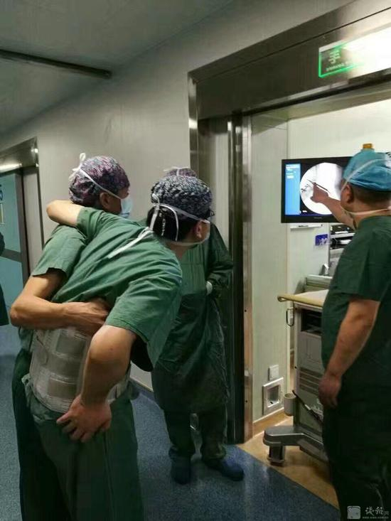 医生带护具被搀扶进手术室