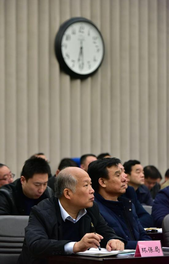 2016年12月30日晚，胡建森在新乡市大气污染防治推进会上。摄影/章轲