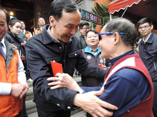 　　新北市长朱立伦上午分别到永和保福宫、中和广济宫参拜，并发放福袋红包。（图片来源：台湾《联合报》）