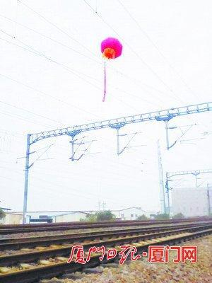 气球悬在接触网上，致列车延误。