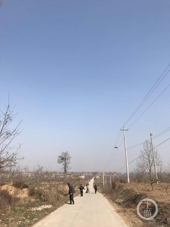 图为村民在打扫公路。