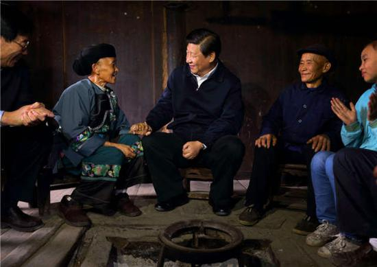 　　2013年 11月3日，习近平在湘西土家族苗族自治州花垣县排碧乡十八洞村苗族村民施齐文家中同一家人促膝交谈。新华社记者兰红光摄