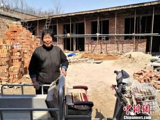 张焕枝背后是正在盖的新房。摄影|中新社记者 陈林