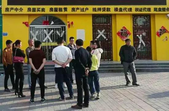 安新县湿地华城楼盘外聚集的外地购房者，房产中介已贴上封条。