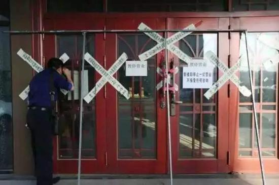  一名外地购房者在明珠湾楼盘销售中心外向内观看。&nbsp;