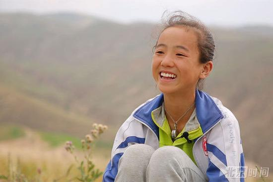 （“春蕾女童合唱团”成员在北京时间的镜头前绽放微笑）