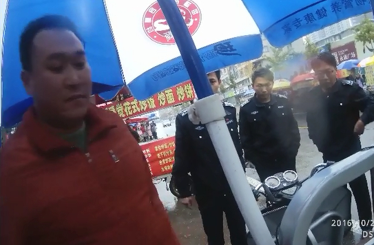 城管扣车导致双方发生争执，随后张军虎拔刀刺向城管。视频截图