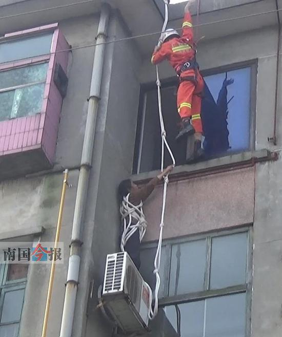 　　19日上午，柳州市永前路六区出现惊魂一幕：一名妇女因忘带钥匙进不了家门，竟想绑绳爬窗回家，结果悬在半空。消防官兵和民警及时赶到将她救回。图为消防官兵从空中降下成功救人。通讯员&nbsp;唐恒摄