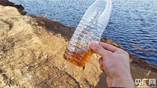 　　记者用矿泉水瓶盛出一些坑内的水体，呈半透明的棕色，气味更加明显。（（央广记者 白杰戈 王逸群 摄））