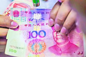 　　工作人员用紫光笔照射真假一百元，上面“100”字样偏蓝的为假钞，下面“100”字样偏黄的为真钞。 　　广州日报全媒体记者陈忧子 摄