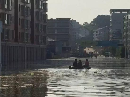 7月3日，梅树村民兵营长付晓光在积水中巡逻。新京报记者安钟汝 摄