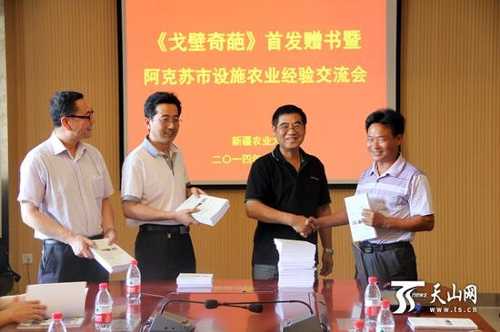 陈青云（右二）在《戈壁奇葩》首发仪式上赠书。（图片由陈青云提供）