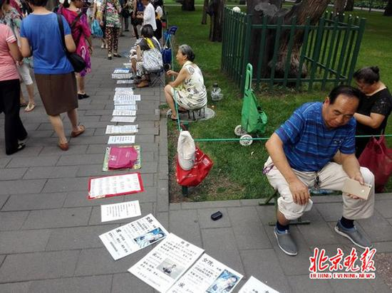 有的坐在小板凳上，面前摆着一块纸板；有的捧着纸板。 &nbsp;本文图片均为北京晚报 图