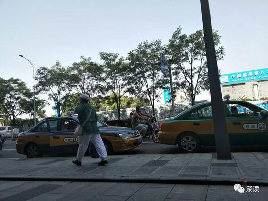 在新世界酒店门前趴活的出租车，其中一辆（左一）带着记者大讲“北京五气”