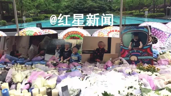 　　▲事发小区内摆放着死者生前的照片进行祭奠：死者是一位母亲和她的三个孩子 &nbsp; &nbsp;图片来源：红星新闻